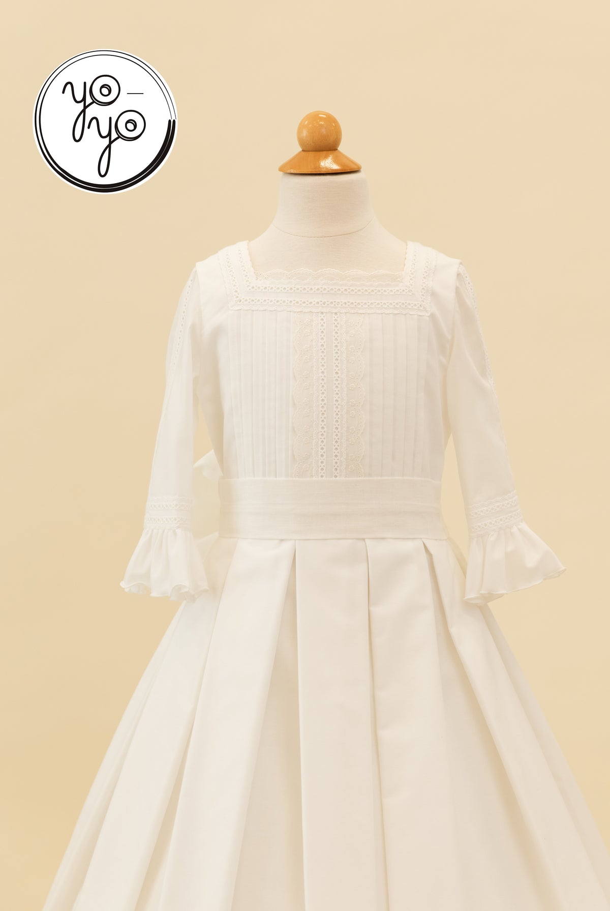 Claudine Dress by YoYo Boutique: a white, French Riviera-style gown featuring a square neckline, lace trim, a pleated bodice, and ruffled cuffs.