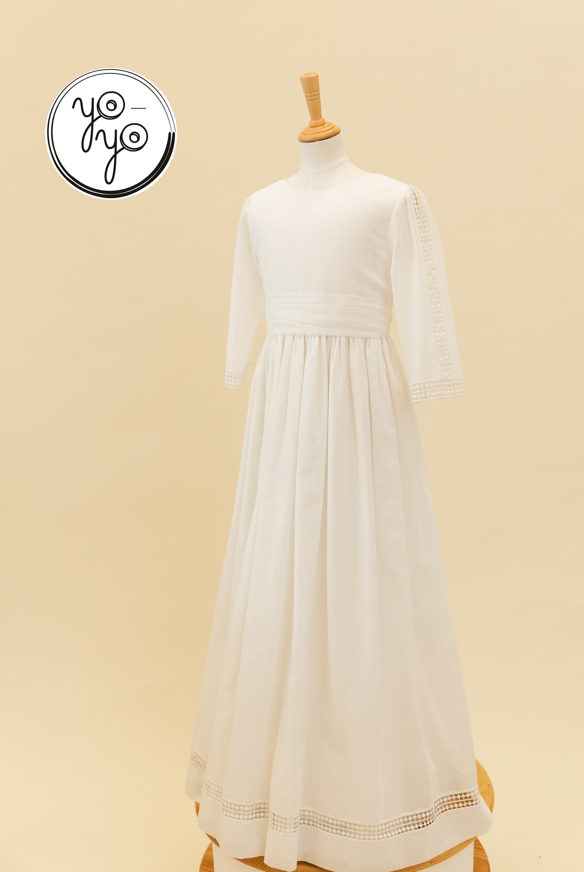 YoYo Boutique Montserrat communion dress in white linen. A floor-length, long-sleeved gown featuring a round neckline and lace trim.