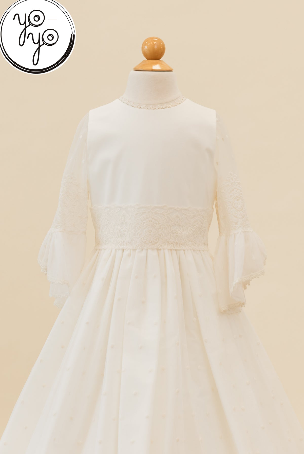 Manon Dress by YoYo Boutique in ivory. Boho style with a round neckline, lace waist trim, and sheer three-quarter length bell sleeves on a mannequin.