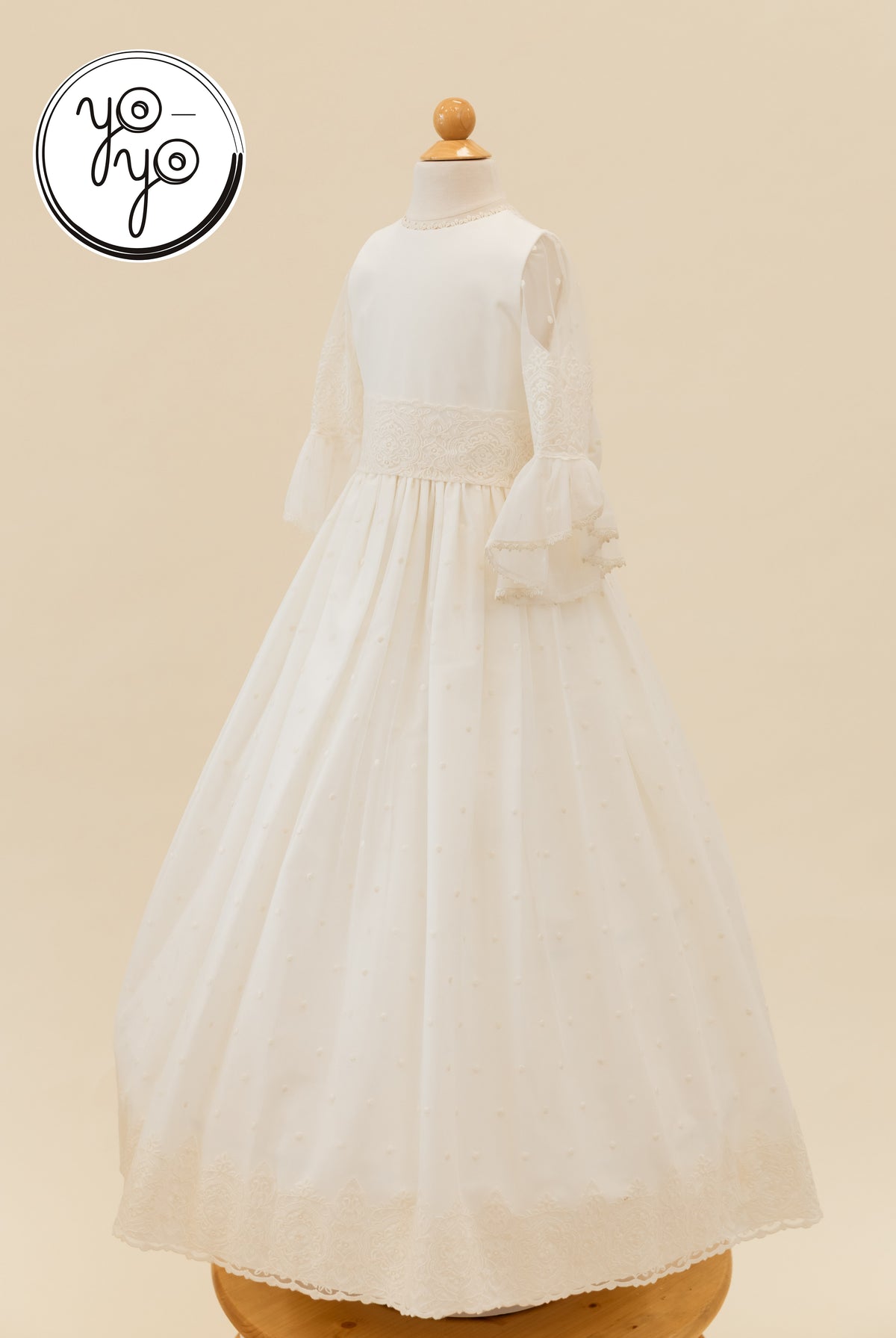 Off-white Manon boho dress on a mannequin, featuring a round neck, lace-trimmed bell sleeves, and a textured swiss dot skirt with a lace hem.