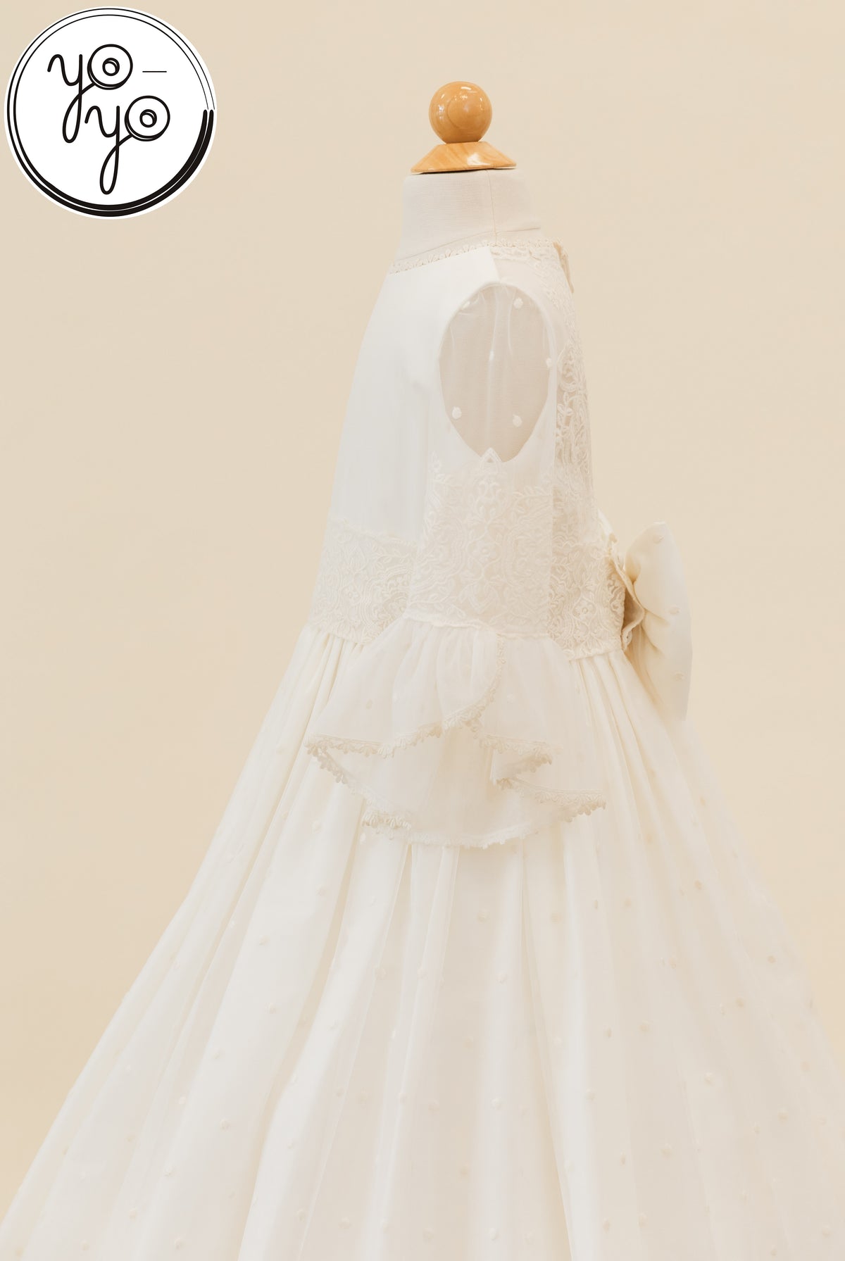 Manon Dress in ivory embroidered tulle featuring a lace bodice, sheer sleeves with ruffled cuffs, and a large back bow.