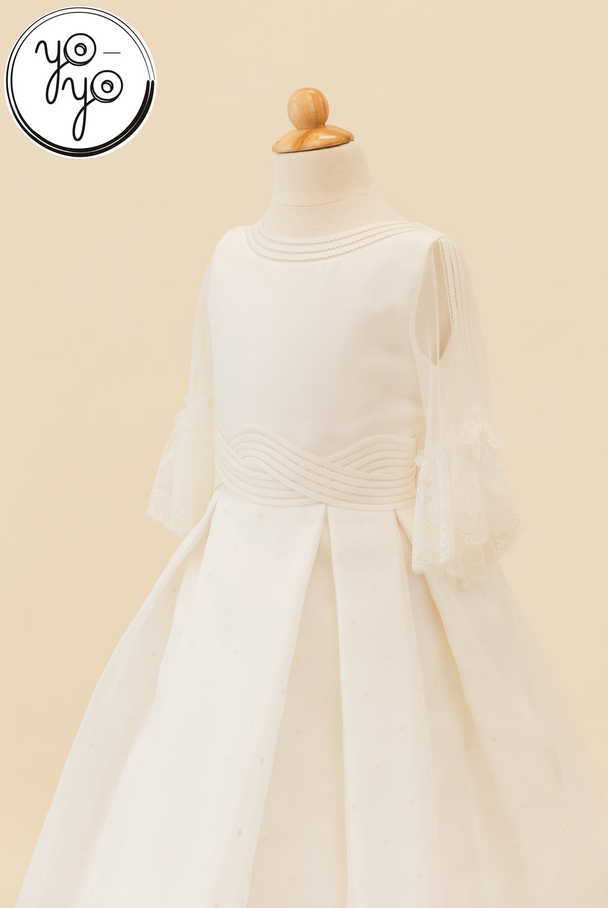 Off-white Ceibo Dress featuring a pleated skirt, lace-edged French sleeves, and a cross-over waistband.
