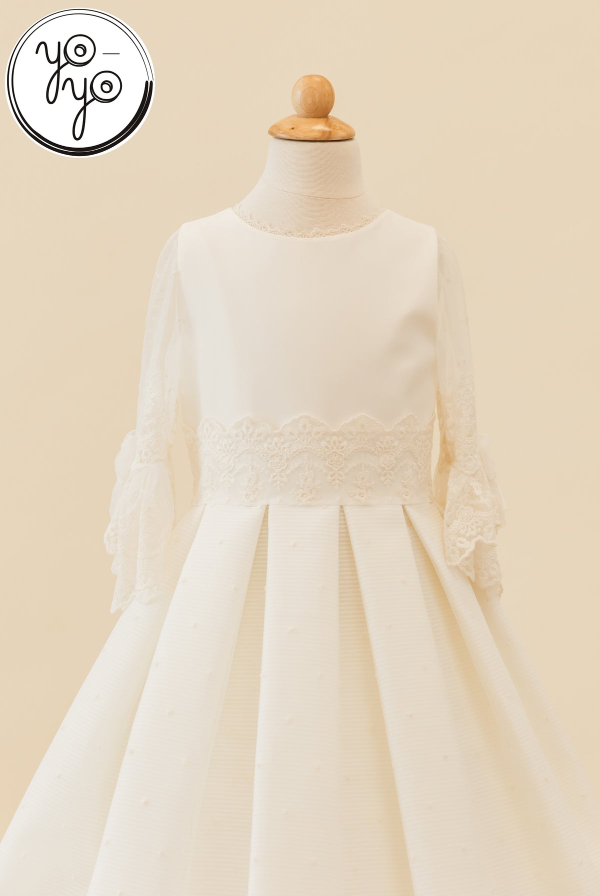 Ivory Giselle Deluxe boho dress with a lace-trimmed round neckline, sheer flared lace sleeves, and a pleated skirt with a lace waist.