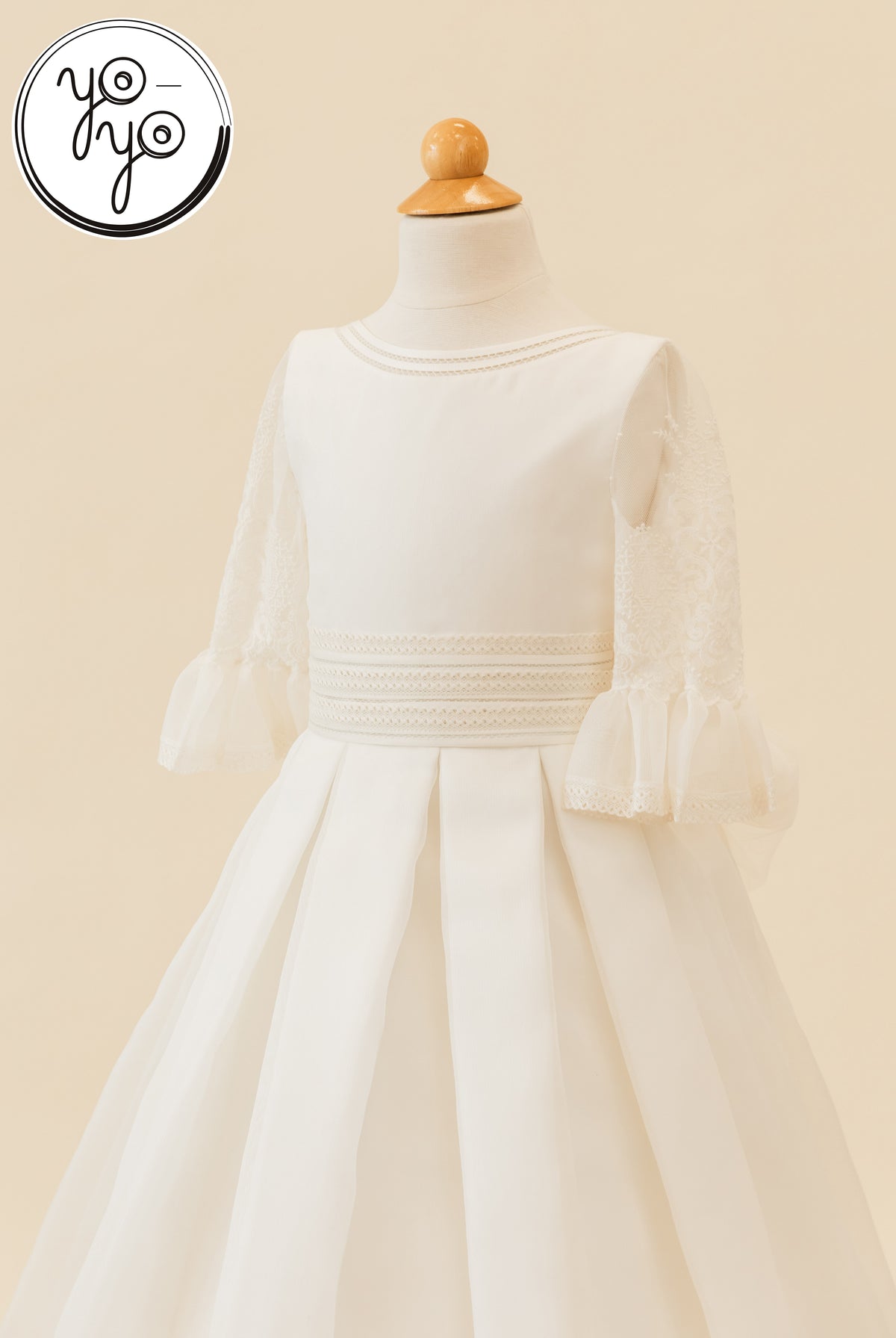 White Magnolia dress with a round neck, embroidered lace elbow-length sleeves with ruffled cuffs, and a pleated skirt.