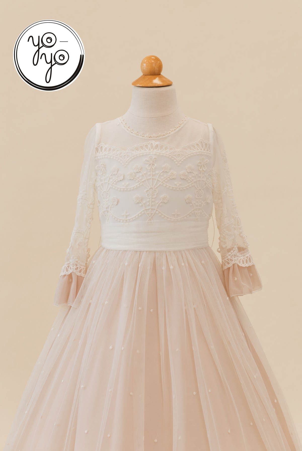 Cream Lua Dress by YoYo Boutique with a lace bodice, sheer lace sleeves, and a tiered tulle skirt accented with small pearls.