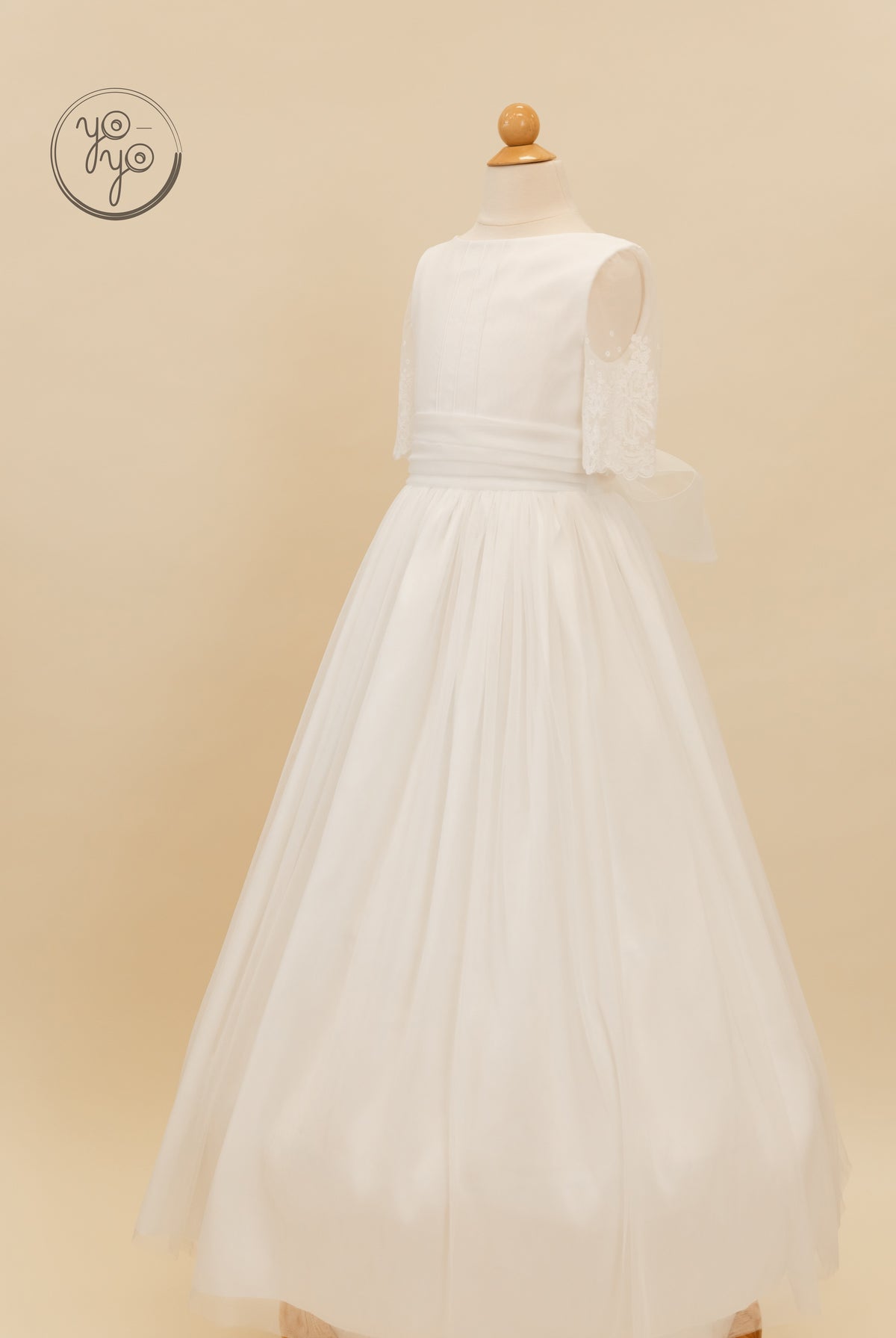 Nigella Dress by YoYo Boutique: a white floor-length gown featuring a lace bodice, short sleeves, a waist sash, and a French tulle skirt.