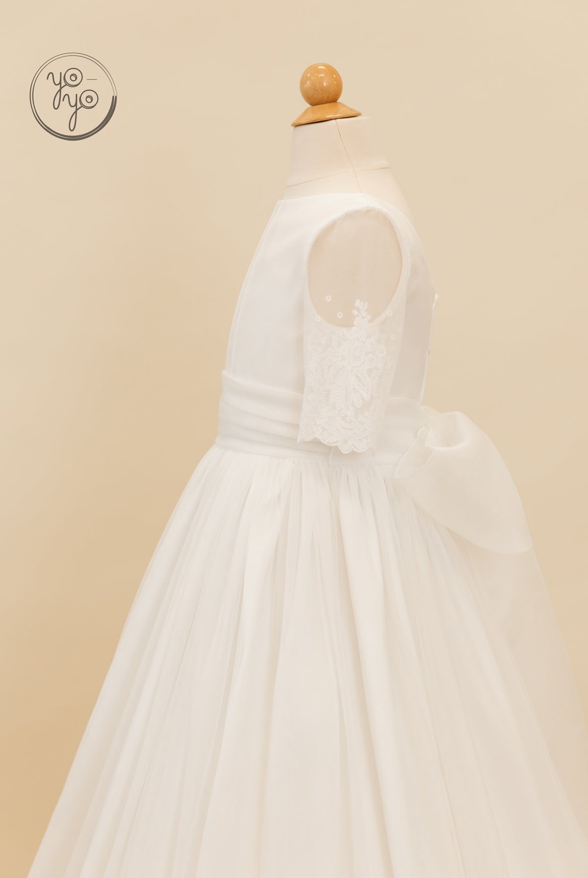 White Nigella dress featuring a French tulle skirt, lace-trimmed sleeves, and a large bow at the back waist.