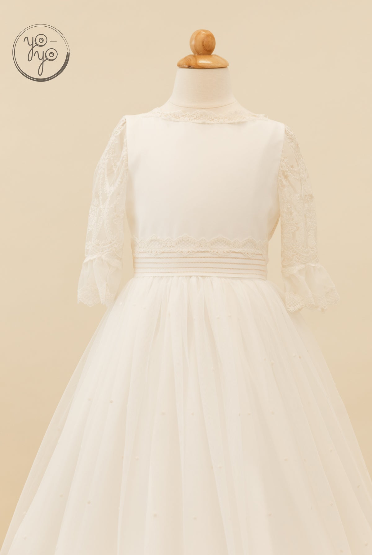 Back view of the ivory Nerina Dress by YoYo Boutique, featuring three-quarter lace sleeves, a lace-trimmed bodice, and a full tulle skirt.