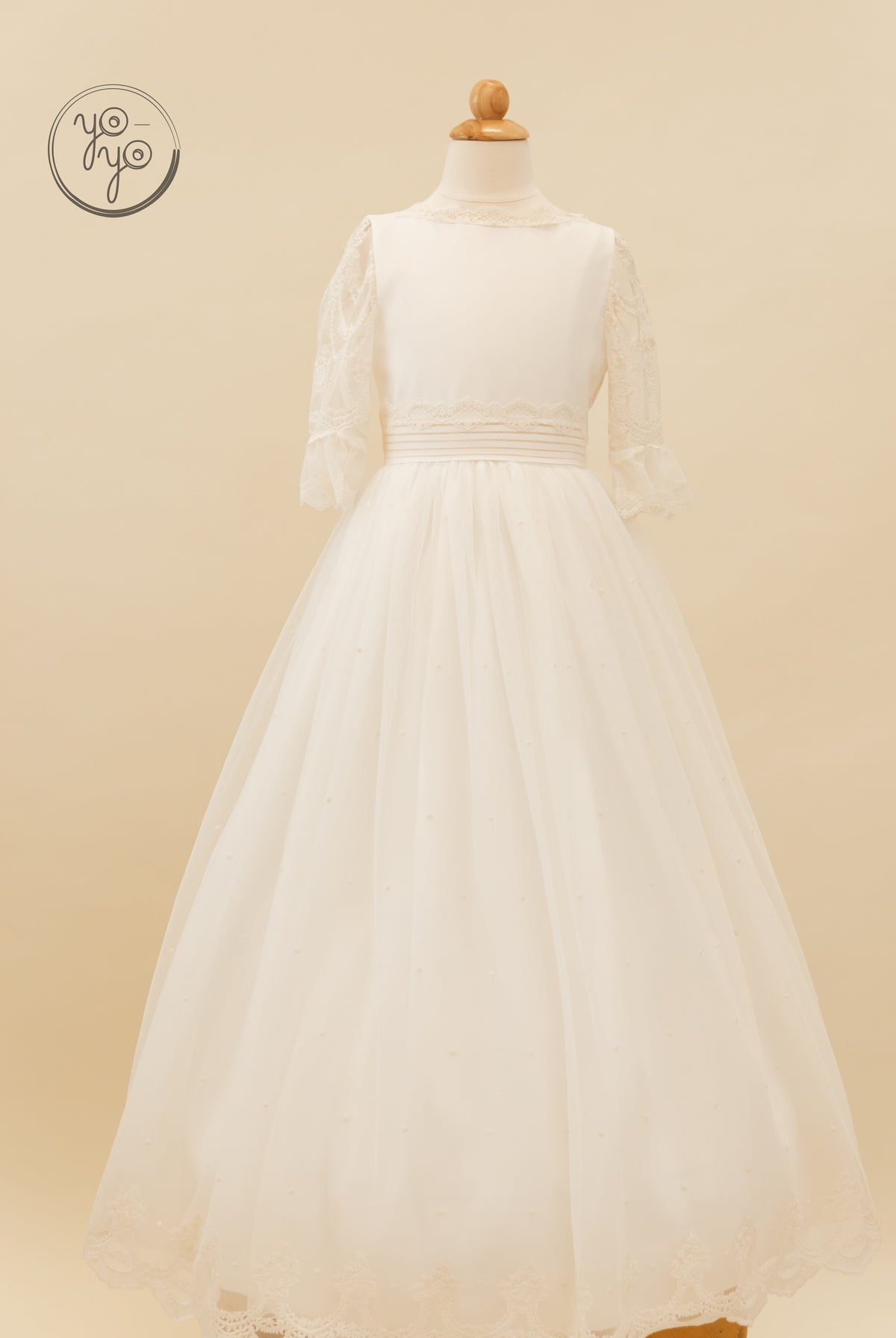 Cream-colored boho Nerina dress featuring lace sleeves, a high neckline, a pleated waistband, and an embellished French tulle skirt.