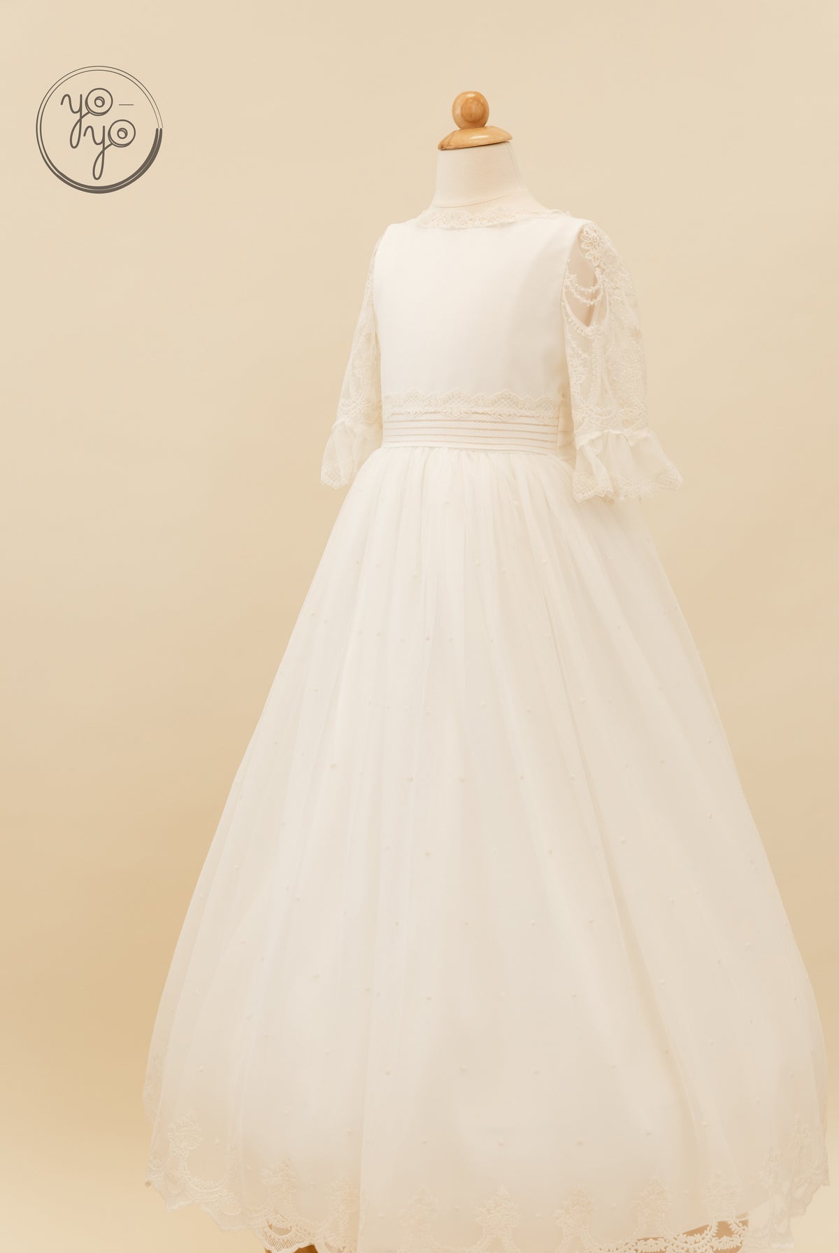 Nerina dress in ivory French tulle with a round neck, lace sleeves, and a tiered skirt with pearl accents.