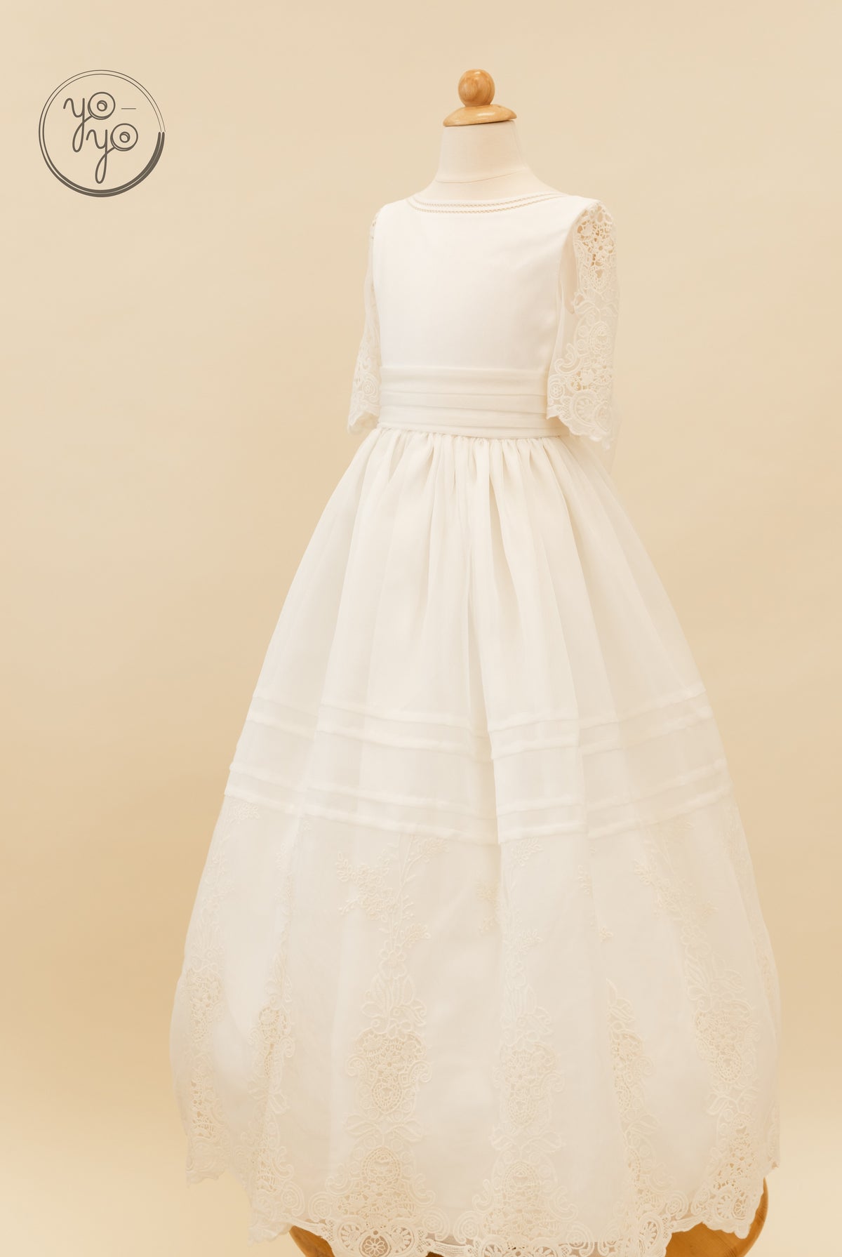 Off-white floor-length boho Coral Dress on a mannequin, featuring a round neckline, elbow-length lace sleeves, and an embroidered lace hem.