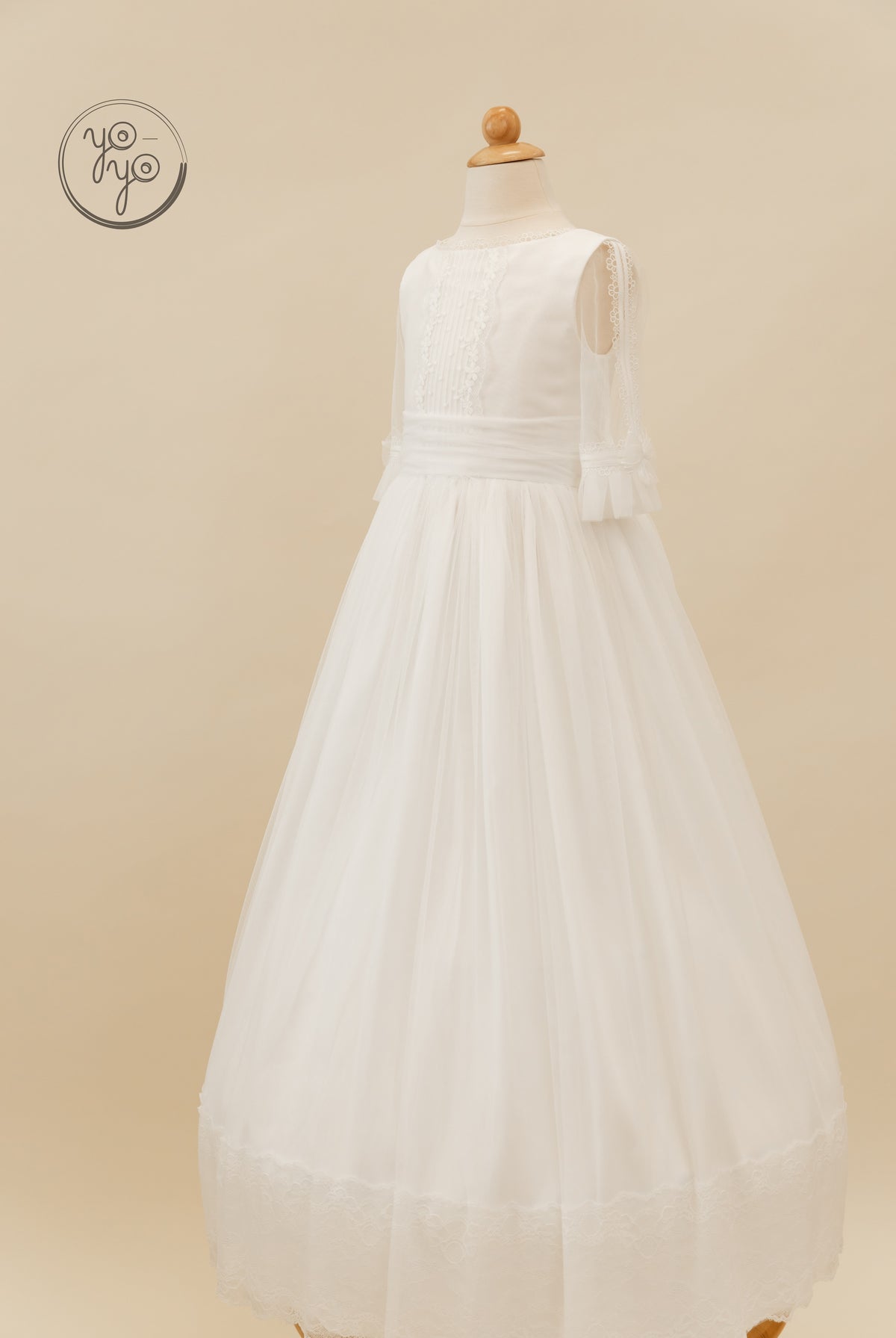 White Valeriana Dress by YoYo Boutique, featuring a floor-length tiered French tulle skirt, lace bodice, and sheer sleeves.