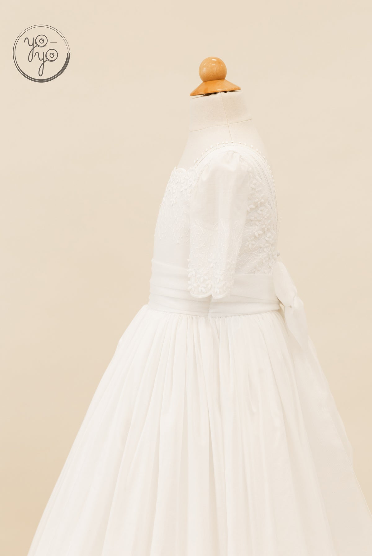 YoYo Boutique Salvia dress: white short-sleeved formal dress featuring floral embroidery, a wide waist sash, and a full-length pleated skirt.