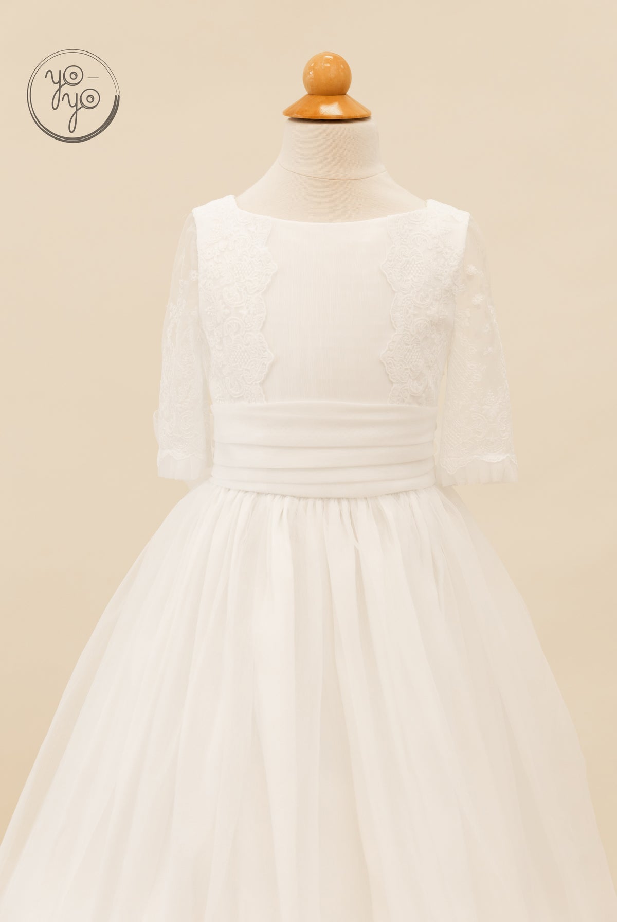 YoYo Boutique Gladiola Dress: a white boho gown on a mannequin featuring a wide waistband, lace bodice panels, and sheer three-quarter sleeves.