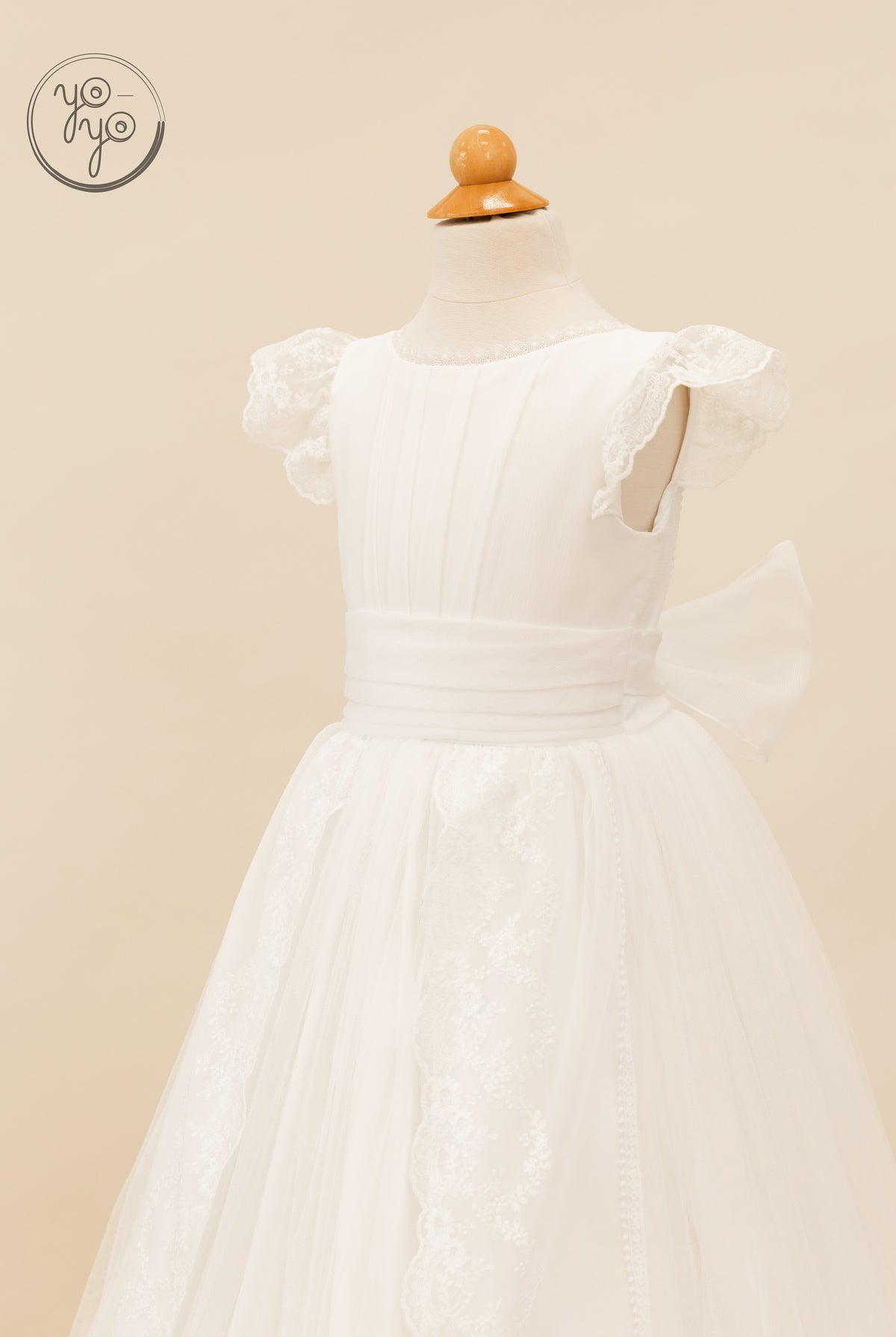 White sleeveless Buganvilla dress featuring a lace-trimmed bodice, pleated waist, and a tulle skirt with floral lace panels.