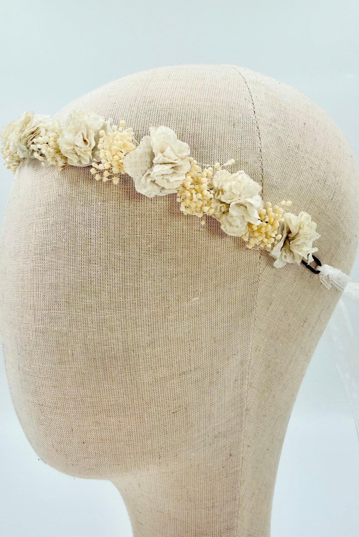 Off-White Flower Headpiece by YoYo Boutique: a handmade fabric flower crown on a mannequin head, finished with a thin lace ribbon tie at the back.